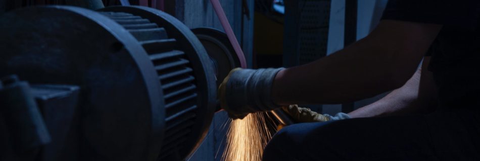 man grinding a metal