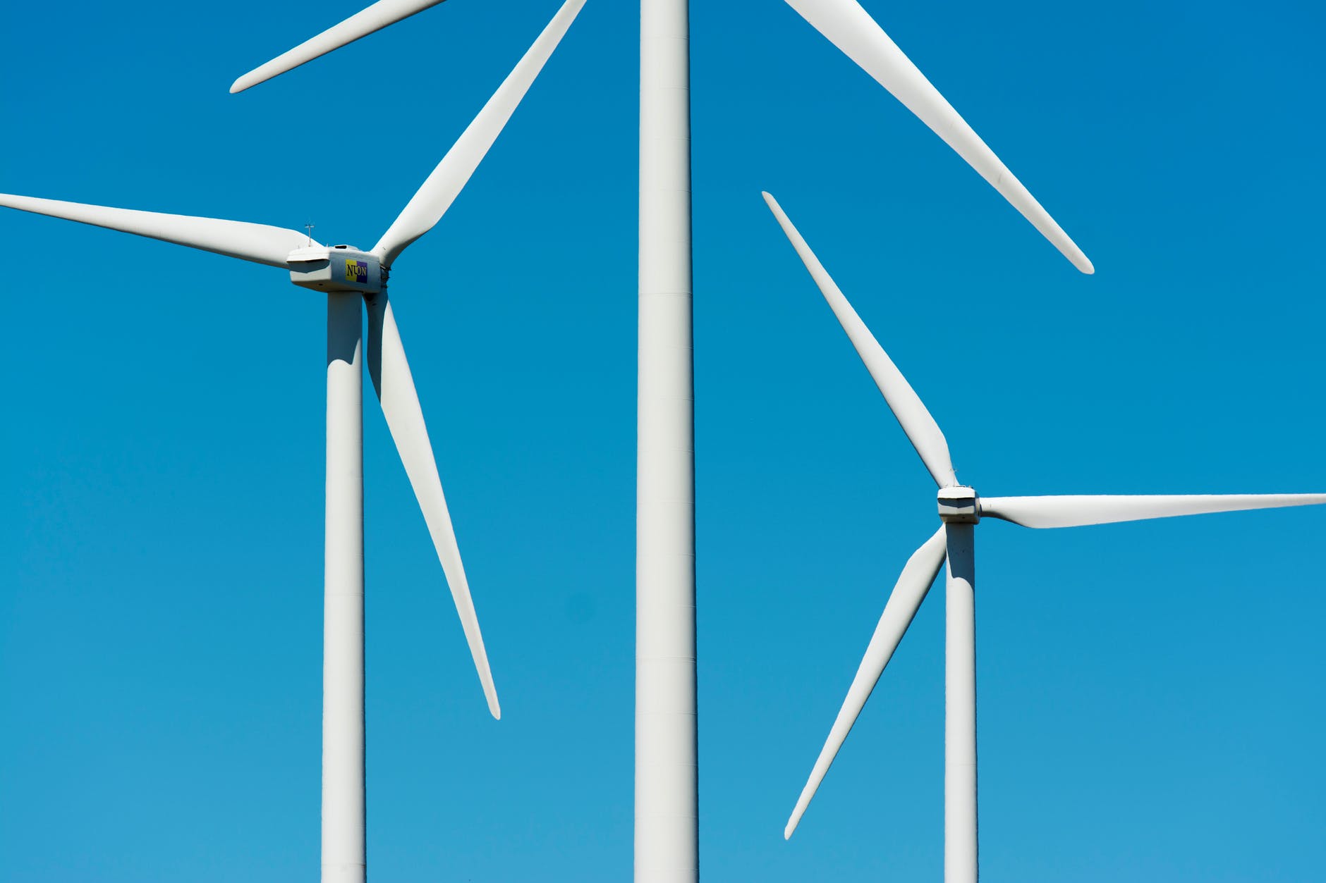 white wind turbine under blue sky