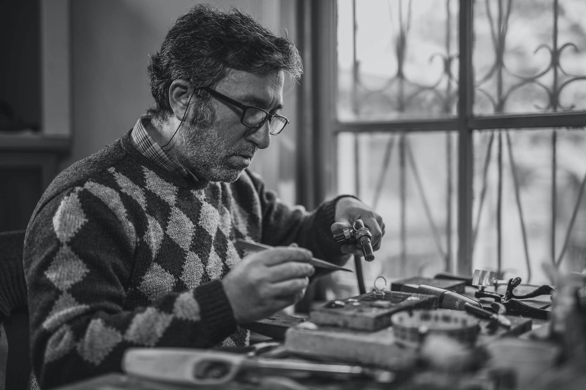 grayscale photo of man holding tools